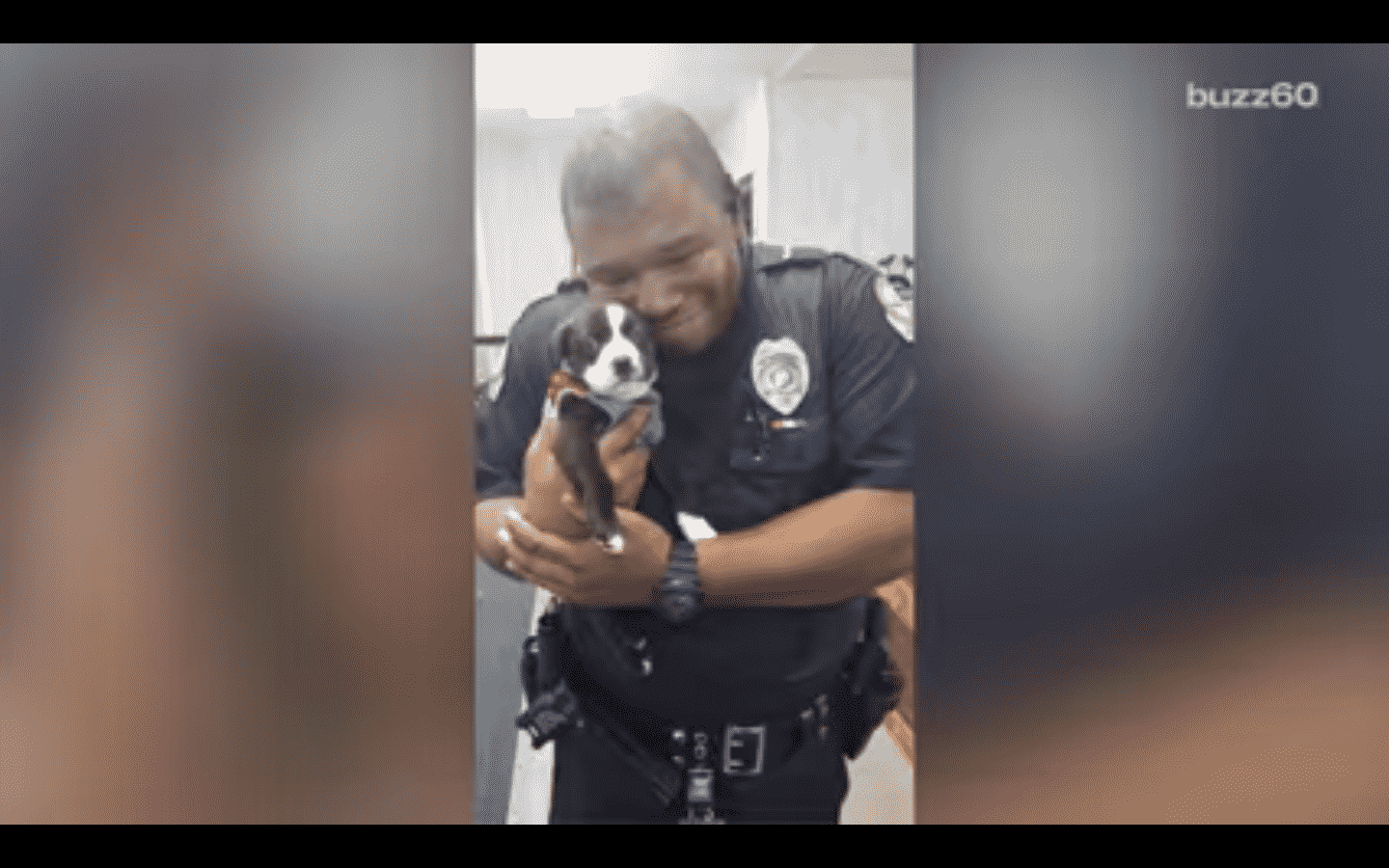 officer holding a small puppy